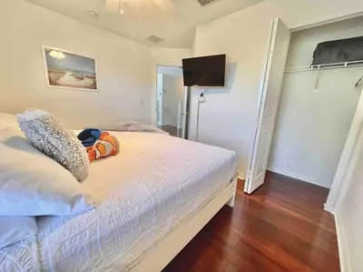 a bedroom with a bed and a flat screen tv at 7BD 5BA w Pool Spa Home 10 mins away to Disney in Kissimmee