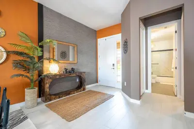 a living room with a fireplace and orange walls at Welcome to The Lion Nest. A Savanna-Inspired Oasis in Orlando