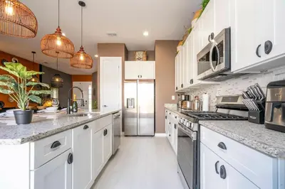 a kitchen with white cabinets and stainless steel appliances at Welcome to The Lion Nest. A Savanna-Inspired Oasis in Orlando