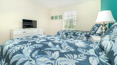a bedroom with two beds with a blue and white blanket at Storey Lake *10 mim -> Disney* 4Q/3Ba in Kissimmee