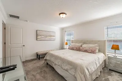 a white bedroom with a bed and a window at Casa luxuosa 4BD/3BA * Storey Lake * in Kissimmee