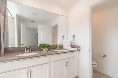 a bathroom with two sinks and a large mirror at Casa luxuosa 4BD/3BA * Storey Lake * in Kissimmee