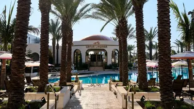 a resort with palm trees and a swimming pool at Universal's Helios Grand Hotel, a Loews Hotel in Orlando