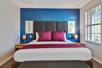 a bedroom with a large bed with purple pillows at 2 Suítes c/ Jacuzzi • 10min da Disney in Kissimmee