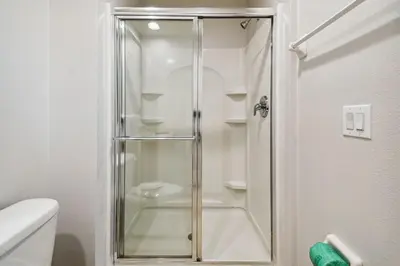 a shower with a glass door in a bathroom at 2 Suítes c/ Jacuzzi • 10min da Disney in Kissimmee