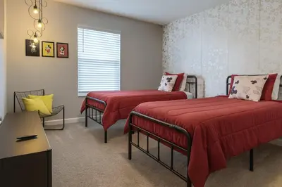 a bedroom with two beds with red sheets and a window at 4Q/3B * Nova e Luxuosa c/Piscina Priv * in Kissimmee