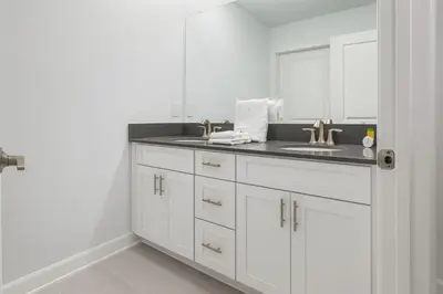 a white bathroom with a sink and a mirror at 4Q/3B * Nova e Luxuosa c/Piscina Priv * in Kissimmee