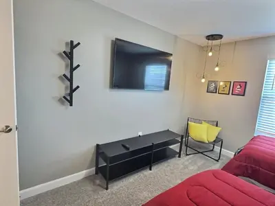 a living room with a red couch and a flat screen tv at 4Q/3B * Nova e Luxuosa c/Piscina Priv * in Kissimmee