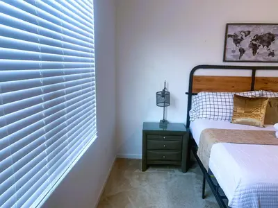 a bedroom with a bed and a window with blinds at Magic Kingdom Villa - Private Master Bedrooms in Kissimmee