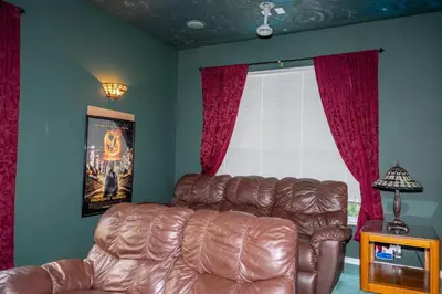 a living room with a leather couch and a window at Waterslide 6 bed Lux Villa Emerald Island in Kissimmee