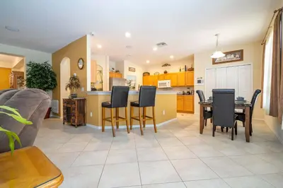 a kitchen and living room with a table and chairs at Waterslide 6 bed Lux Villa Emerald Island in Kissimmee