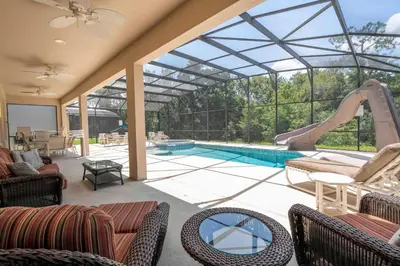 an indoor pool with a slide and a swimming pool at Waterslide 6 bed Lux Villa Emerald Island in Kissimmee