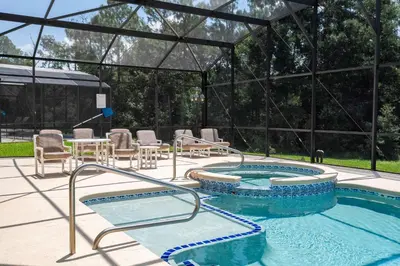 a pool with two hot tubs and a table and chairs at Waterslide 6 bed Lux Villa Emerald Island in Kissimmee