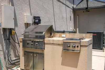 a outdoor kitchen with a grill and a stove at Waterslide 6 bed Lux Villa Emerald Island in Kissimmee