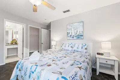 a bedroom with a bed with a blue and white comforter at 6 Bedroom Villa - Emerald Island Retreat in Kissimmee