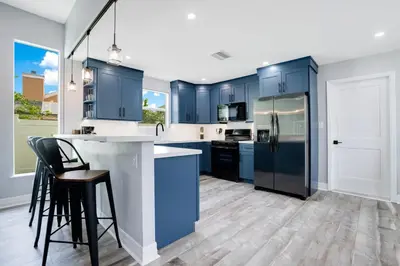 a kitchen with blue cabinets and black appliances at Luxury Villa Near Disney I Fully Renovated in Kissimmee
