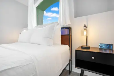 a bedroom with a white bed and a window at Luxury Villa Near Disney I Fully Renovated in Kissimmee