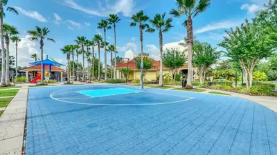 a basketball court at a resort with palm trees at Summer Getaway - 5-Bedroom Home with Private Pool! in Kissimmee