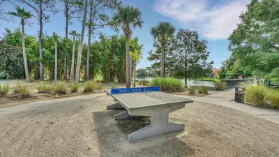 a picnic table in a park with a sign on it at Summer Getaway - 5-Bedroom Home with Private Pool! in Kissimmee