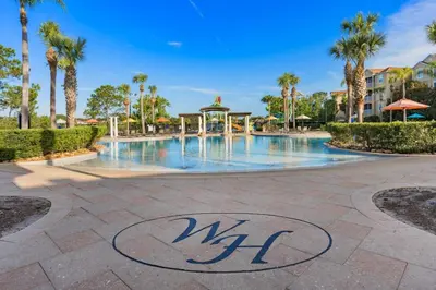 a swimming pool at a resort with palm trees at Wheelchair-Friendly Villa Near Disney World in Orlando