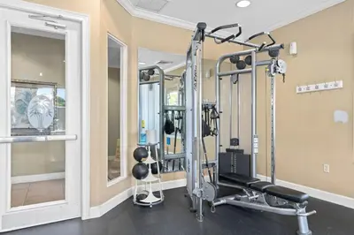 a fitness room with a gym with tread machines at Wheelchair-Friendly Villa Near Disney World in Orlando