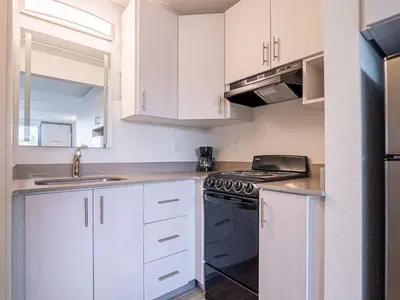 a kitchen with white cabinets and a black stove top oven at Luxury Orlando Condo Next to Disney with lake view in Kissimmee