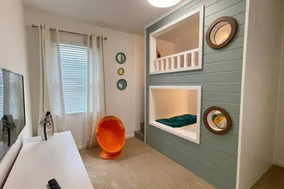 a bathroom with a sink and a mirror and a chair at 3841 Kalistoga Stylish Villa 7BD Private Pool and Game Room in Kissimmee