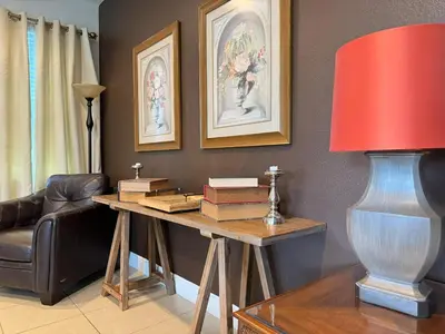 a living room with a desk with books and a lamp at 7738-IBRHAIM · 7738 Fairfax Dream Home in Orlando