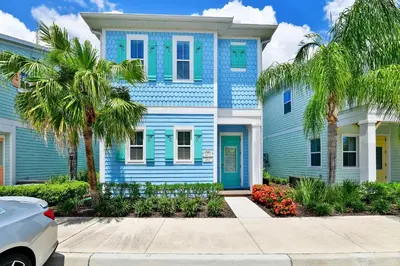 a blue house with palm trees in front of it at Ocean Blue Cottage Near Disney With Private Hot Tub & Margaritaville Resort & Island H20 Waterpark Access - 3012Sr in Orlando