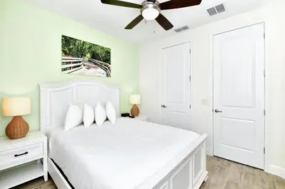 a white bedroom with a white bed and a ceiling fan at Serene Villa Near Disney With Margaritaville Resort & Island H20 Access - 8147Cp in Orlando