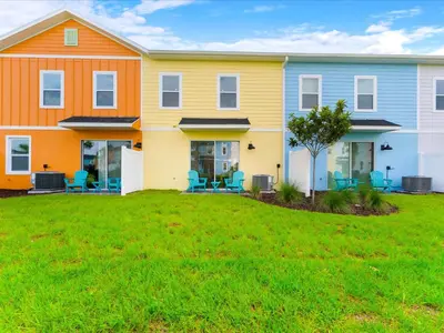 a row of houses on a lawn at Sunshine Villa Near Disney With Margaritaville Resort & Island H20 Waterpark Access - 2922Cl in Orlando