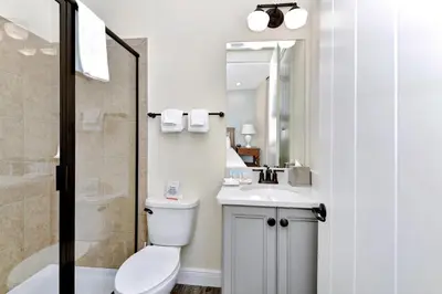 a bathroom with a toilet and a sink and a shower at Blue Moon Luxurious Cottage With Private Pool Near Disney With Margaritaville Resort & Island H2O Access - 8073Su in Orlando