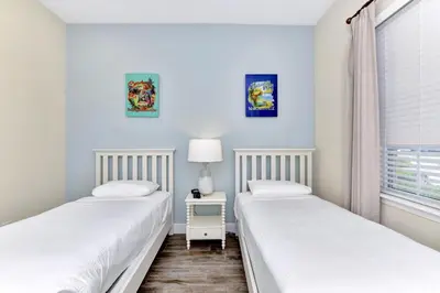 two twin beds in a room with a window at Blue Moon Luxurious Cottage With Private Pool Near Disney With Margaritaville Resort & Island H2O Access - 8073Su in Orlando