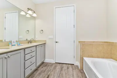 a white bathroom with a tub and a sink at Sunrise Cottage With Private Pool Near Disney With Margaritaville Resort & Island H2O Access - 8017Su in Orlando