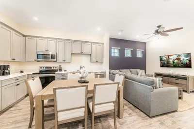 a kitchen and living room with a table and a couch at Seven Saturdays Cottage Near Disney With Margaritaville Resort & Island H2O Access - 3032Sp in Orlando