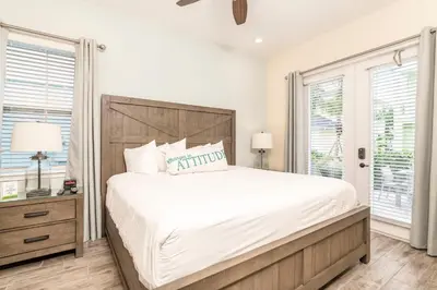 a bedroom with a large bed and two windows at Seven Saturdays Cottage Near Disney With Margaritaville Resort & Island H2O Access - 3032Sp in Orlando