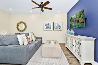 a living room with a couch and a ceiling fan at Pearly White Villa Near Disney With Margaritaville Resort & Island H2O Access - 3061Cs in Orlando