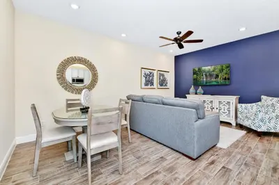 a living room with a couch and a table at Pearly White Villa Near Disney With Margaritaville Resort & Island H2O Access - 3061Cs in Orlando