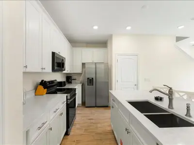 a kitchen with white cabinets and a stainless steel refrigerator at Beautiful Florida Villa Near Disney With Margaritaville Resort & Island H20 Waterpark Access - 2939Cl in Orlando