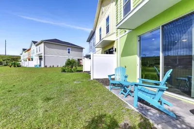 a blue bench sitting on the side of a house at Tropical Green Villa Near Disney With Margaritaville Resort & Island H20 Access - 8142Cp in Kissimmee