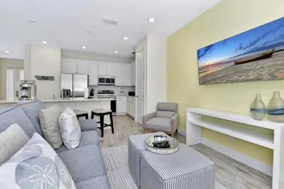a living room with a couch and a kitchen at Blissful Pink Villa Near Disney With Margaritaville Resort & Island H20 Access - 8103Cp in Orlando