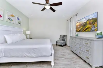 a bedroom with a white bed and a ceiling fan at Blissful Pink Villa Near Disney With Margaritaville Resort & Island H20 Access - 8103Cp in Orlando