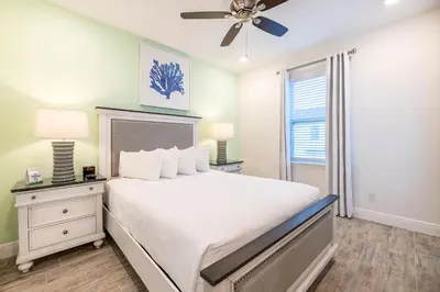 a bedroom with a white bed and a ceiling fan at Vibrant Cottage With Private Pool Near Disney With Margaritaville Resort & Island H2O Access - 8043Kd in Orlando