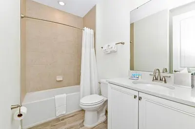 a white bathroom with a toilet and a sink at Cool Cottage Near Disney With Margaritaville Resort & Island H20 Waterpark Access - 3184Cs in Orlando