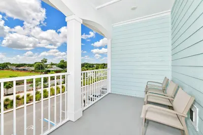 a porch with two chairs and a view of the ocean at Beachy Daze Cottage Near Disney With Margaritaville Resort & Island H20 Waterpark Access - 2916Sr in Orlando