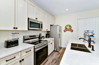 a kitchen with white cabinets and stainless steel appliances at Tangerine Villa Near Disney With Margaritaville Resort And Island H20 Waterpark Access - 8178Cp in Orlando