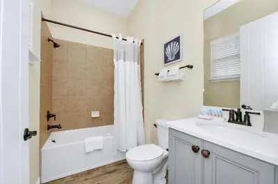 a bathroom with a toilet and a sink and a bathtub at Caraway Cove Cottage Near Disney With Margaritaville Resort & Island H2O Access - 8024Su in Orlando