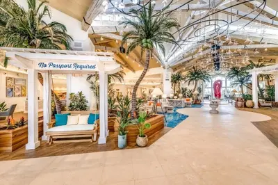 a large lobby with palm trees and plants at Caraway Cove Cottage Near Disney With Margaritaville Resort & Island H2O Access - 8024Su in Orlando