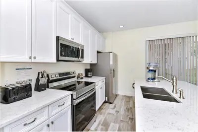 a kitchen with white cabinets and stainless steel appliances at Making Memories Villa Near Disney With Margaritaville Resort & Island H20 Access - 8115Cp in Kissimmee