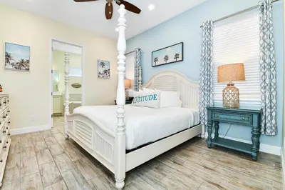 a bedroom with a white bed and a blue wall at Seashell Cream Cottage With Private Pool Near Disney With Margaritaville Resort & Island H2O Access - 8037St in Orlando